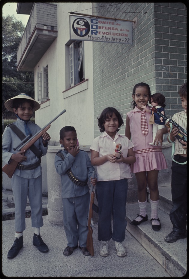 Group of children standing in front of Comite de Defensa de la Revolucion Jose A. Macau