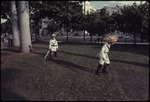 Two children in costume playing in the grass