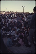 Group of children sitting on the ground at a political rally
