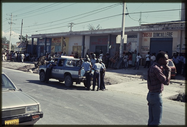 The police standing by their truck in the road during the 1990 Haitian general election