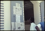 A young man reading about the candidates for the Haitian presidential election in the newspaper "Libete"