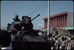 A tank on the street in front of a group of uniformed men during the 1990 Haitian general election