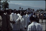 A group of men dressed in white suits shaking hands with Haitian military officers