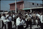 A group of men playing instruments marching in the street