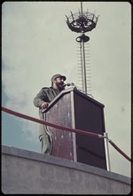 Fidel Castro speaking into a microphone at a podium