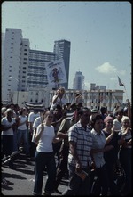 A group of people with Cuban flags and signs demonstrating in the street