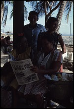 A group of people reading the newspaper, El Diario de Hoy