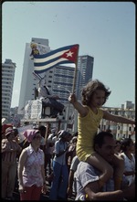 Crowd of people demonstrating with signs and Cuban flag