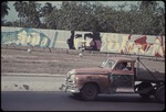 Street scene, truck on street with a banner of Fidel Castro and Che Guevara behind