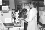 FIU bookstore cashier and two students making a purchase, University House, Florida International University