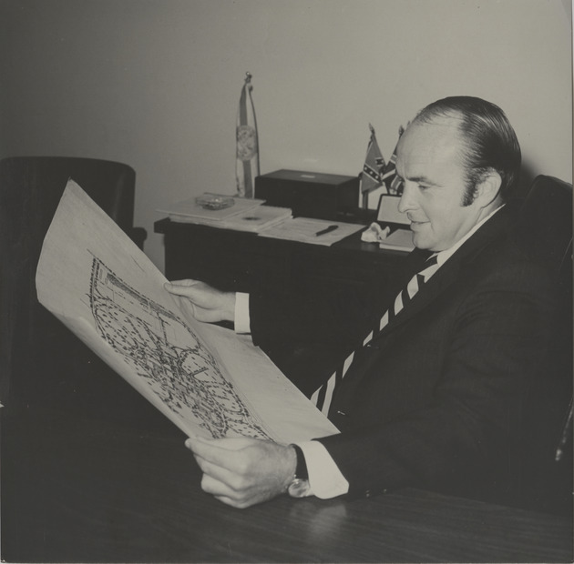 Charles Perry reading a map of Florida International University - Recto