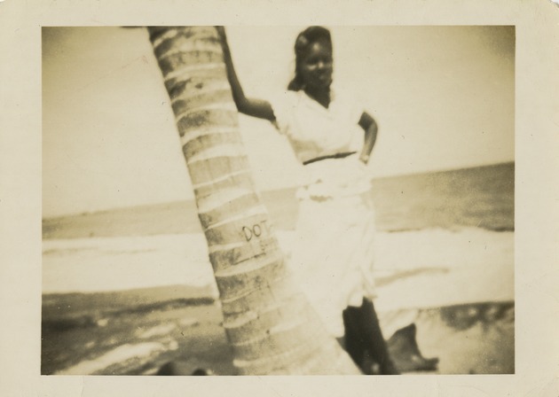 Woman posing next to palm tree