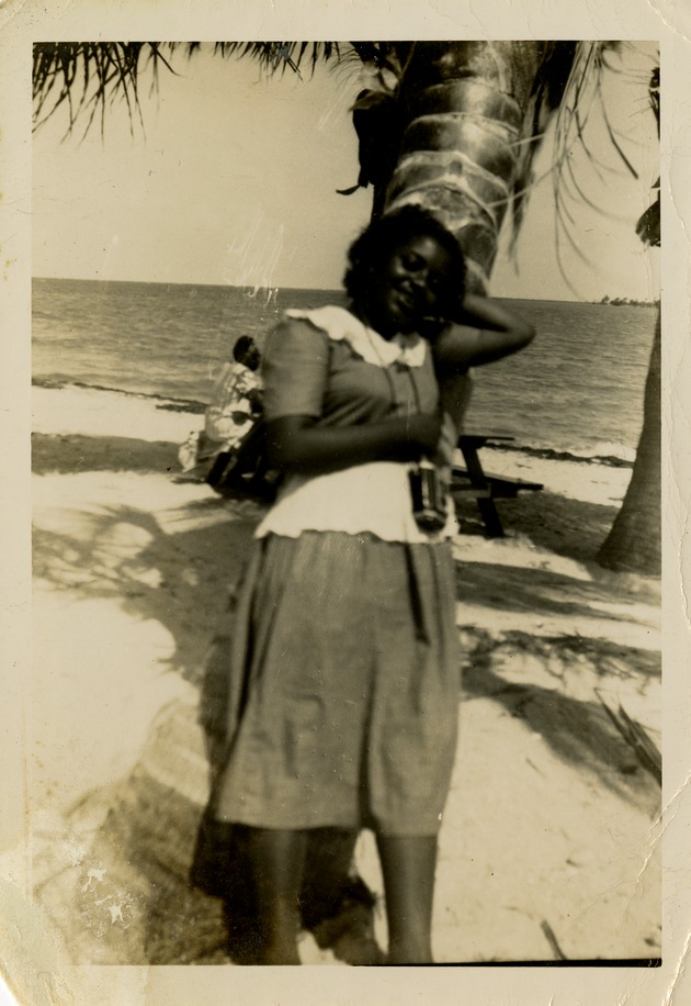 Woman leaning against palm tree - 