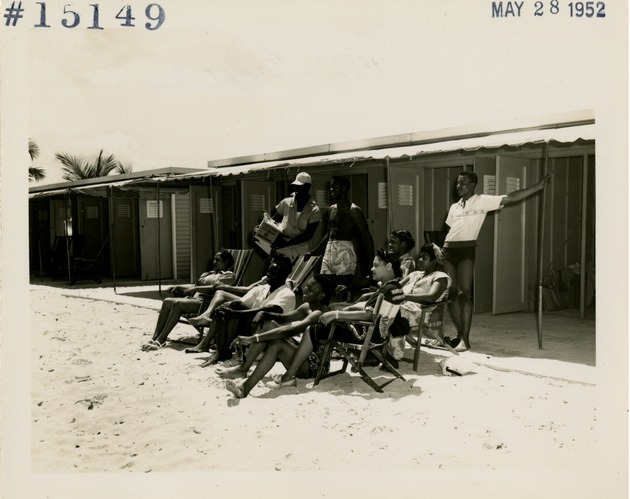 People sitting outside of cabanas - Recto