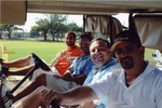 Four men smiling on golf cart
