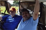 Two men smiling on golf cart