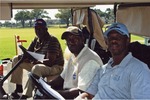 Three men sit in golf cart