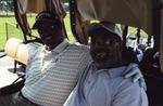 Two golfers smiling in golf cart