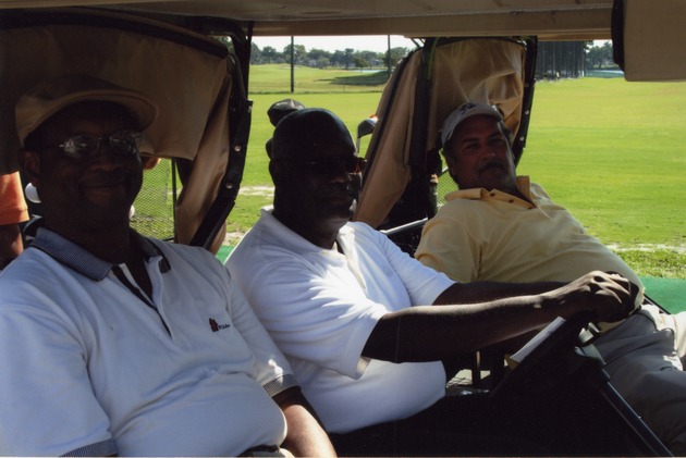 Three men relaxing on golf cart