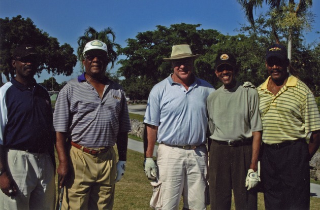 Group of five poses on golf course