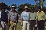 Group of five poses on golf course