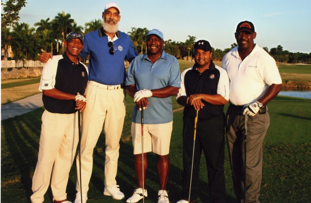 Group of five posing on golf course