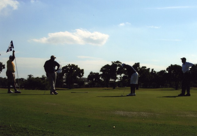 Several men playing golf