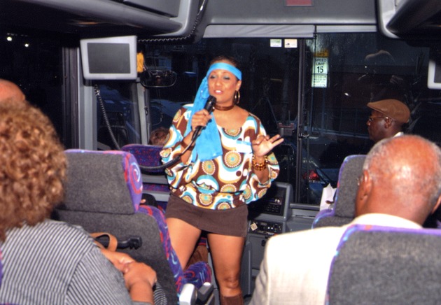 Woman speaks at front of bus