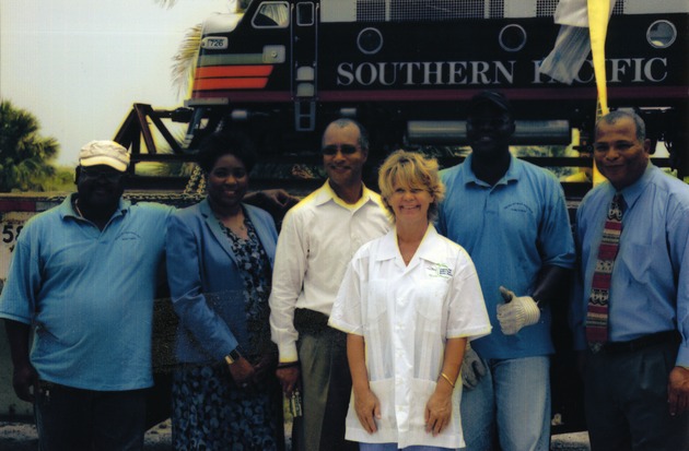 People posing in front of miniature train