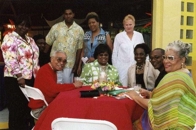 Several people gathered around table smile