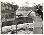 Visitors viewing a Malayan Sun bear and an educational sign at Miami Metrozoo