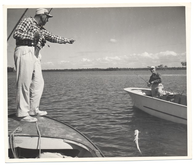 Men on two different boats catching fish