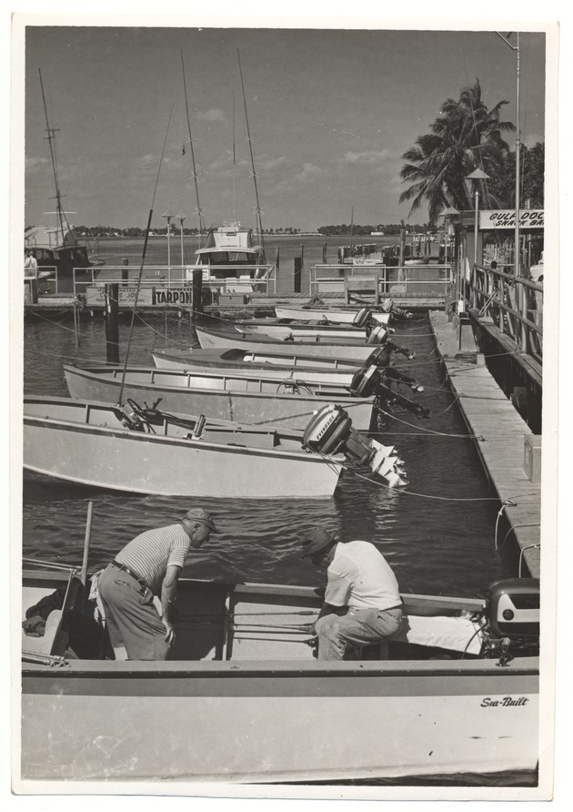 Two men in a boat at the docks