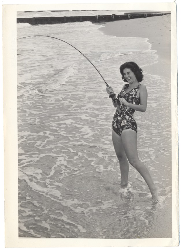 Woman in bathing suit enjoying fishing on the beach