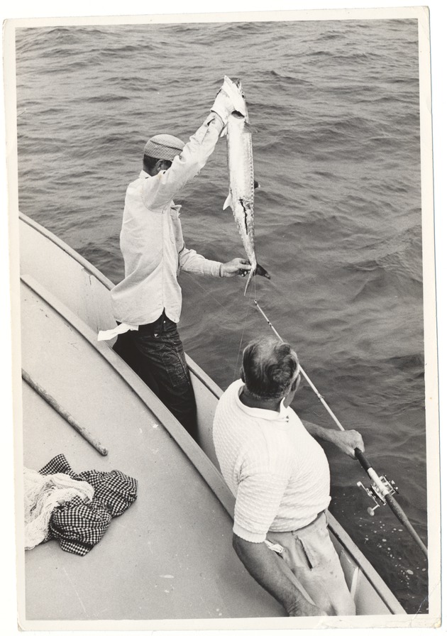 Man picking up a fish from the water