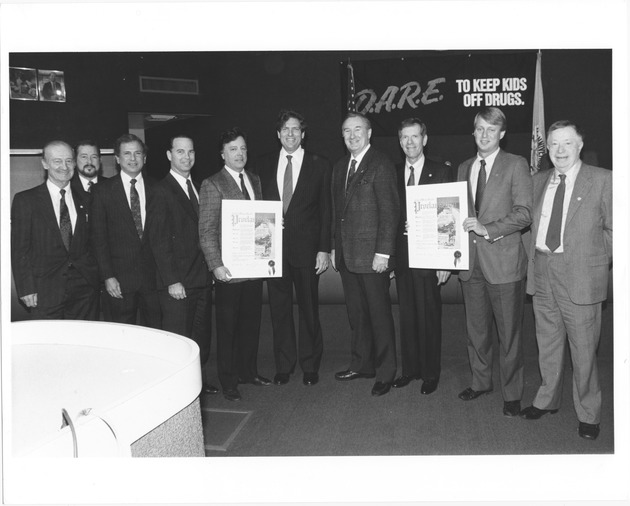Miami Beach City Commission events, 1980s - Photograph, recto: [The City Commission, from left to right Abe Resnick, Rob Parkins (City Manager), Commissioners Martin Shapiro and Bruce Singer accepting Proclamation, Commissioner Billy Schockett, Mayor Alex Daoud, unidentified person, Stanley Arkin, unidentified person and Commissioner Abe Hirschfeld]