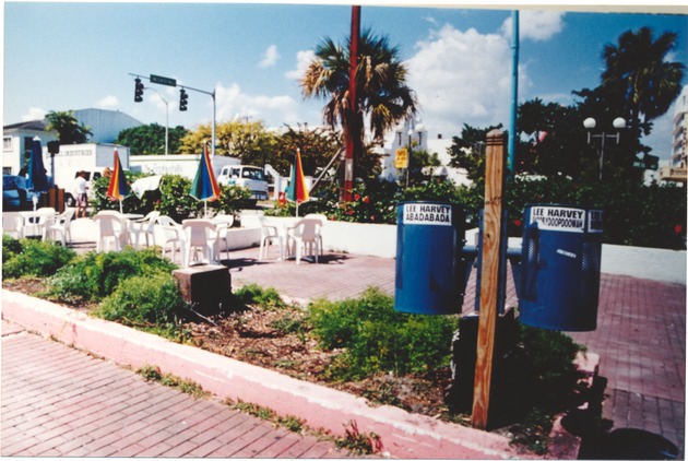 Lincoln Road Mall - Photograph, recto: [View of trash cans and beach chairs with umbrellas on Lincoln Road Mall]