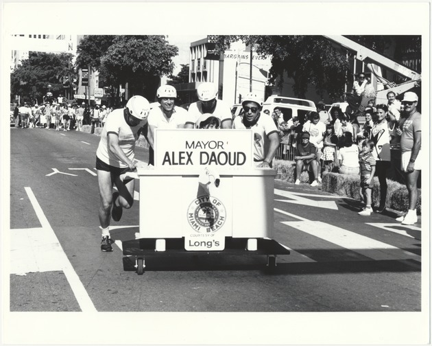 Miami Beach festivals and events, including Desk Dash, 1986 - Photograph: [Downtown Miami's First Annual Desk Dash. Participants included Mayor Alex Daoud and Commissioner Willliam E. Shockett. From Left to Right: Mayor Alex Daoud, a willing participant picked up from the audience, light-heavyweight champion Slobodan Kacar and seating Lori Clapper].