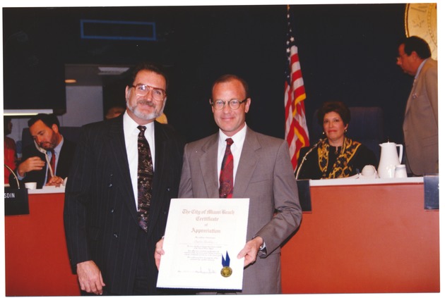 Recipients of Miami Beach proclamations and certificates of achievement, 1994 to 1996 - Photograph, recto: [Mayor Gelber presents certificates of appreciation]. 