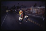 Woman and two children walk on street during Miami Beach Festival of the Arts