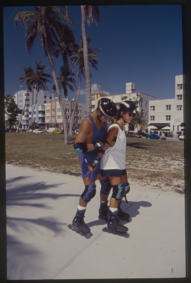 Two people rollerblade at park