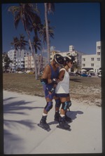 Two people rollerblade at park