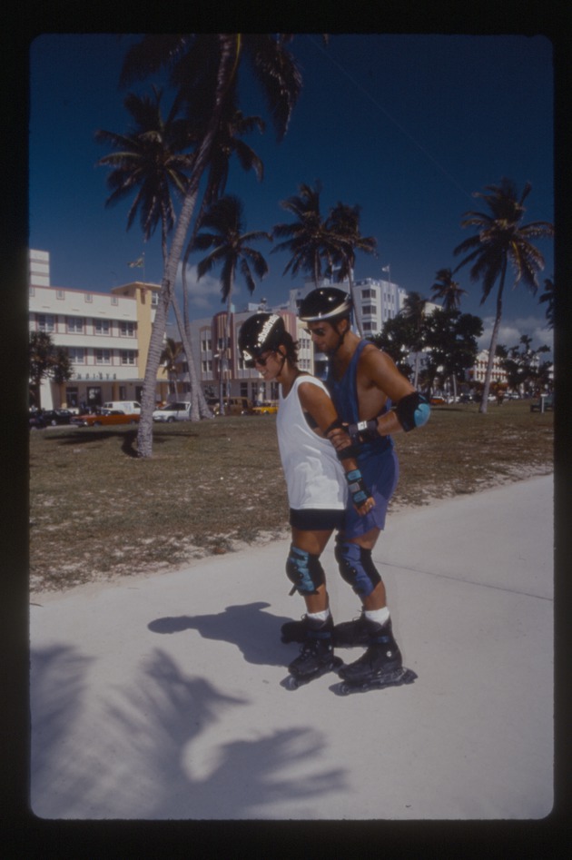 Man and woman rollerblade at park