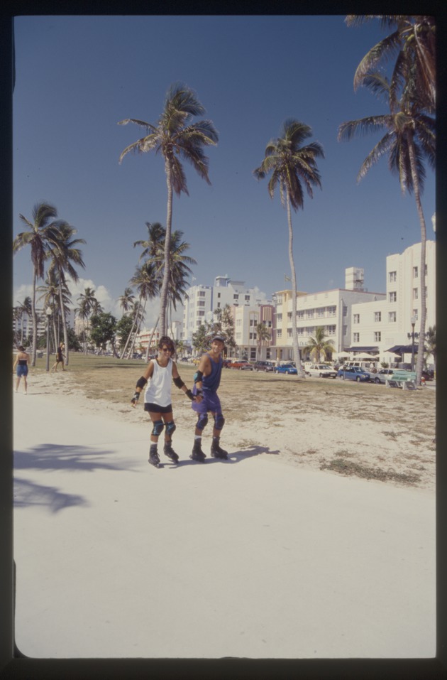 Man and woman hold hands rollerblading