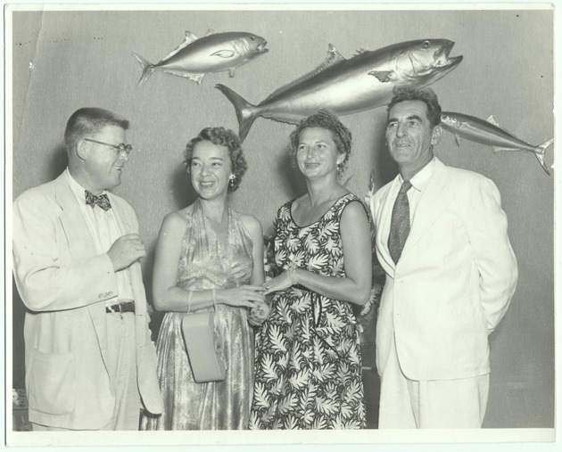People posing in front of fish taxonomy - Recto Photograph