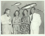 People posing in front of fish taxonomy
