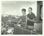 Man with pipe poses on balcony with woman