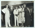 Group standing around a microphone
