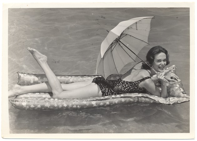 Valerie Jackson floating in the water with a parasol - 