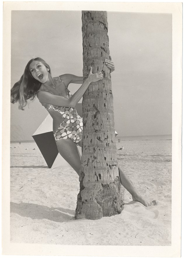 Dominique Doherty grabbing a palm tree by the trunk - 